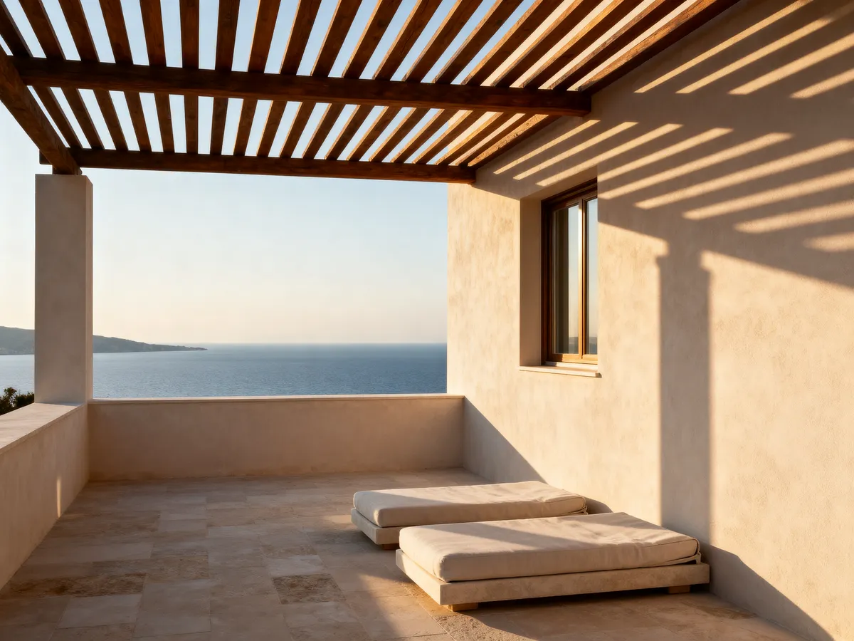 The roof terrace of Atico Sur under a timber pergola, loungers along the parapet and the Mediterranean beyond