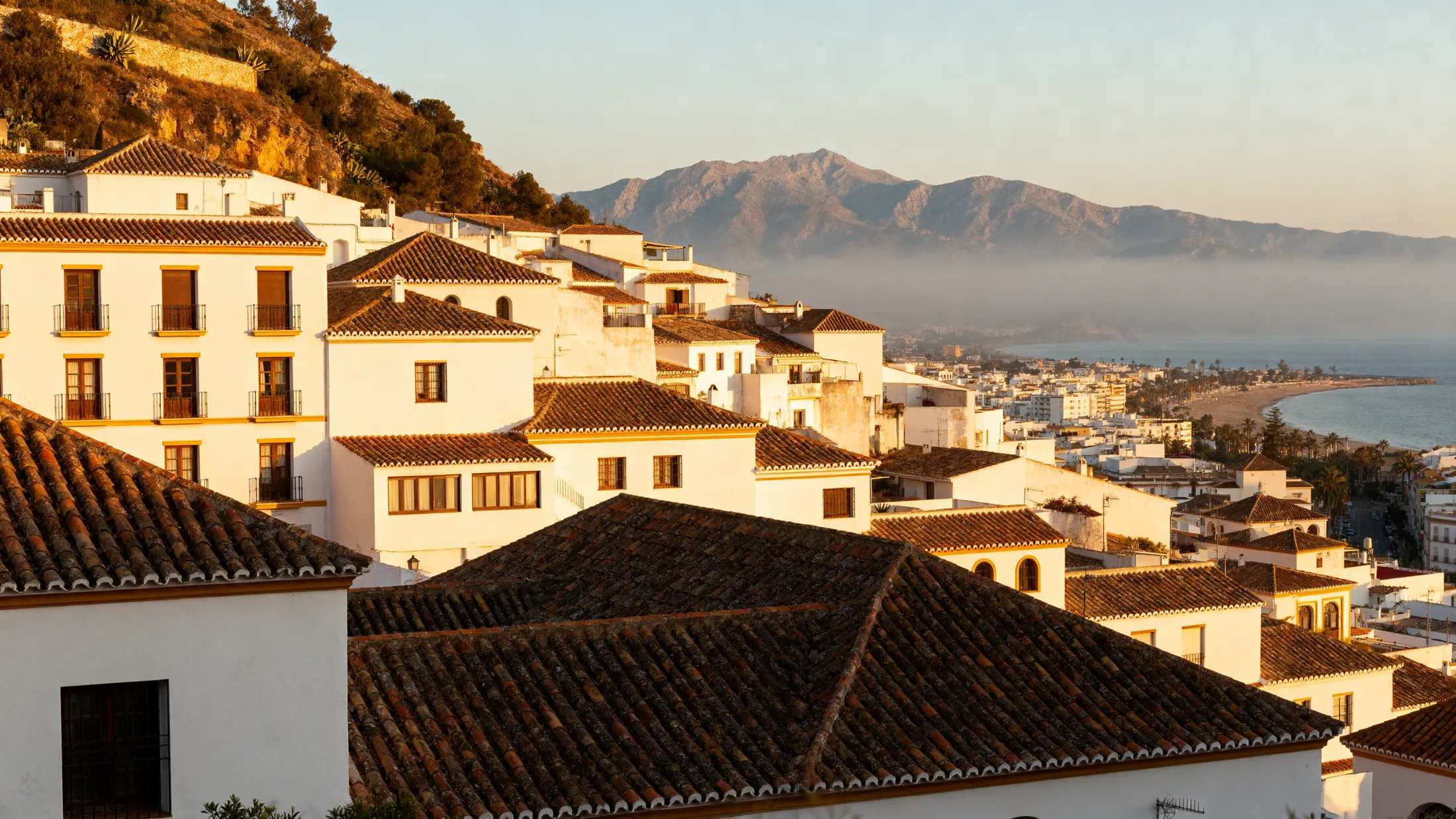 The whitewashed old town of Estepona stepping down to the bay, with the Sierra Bermeja behind